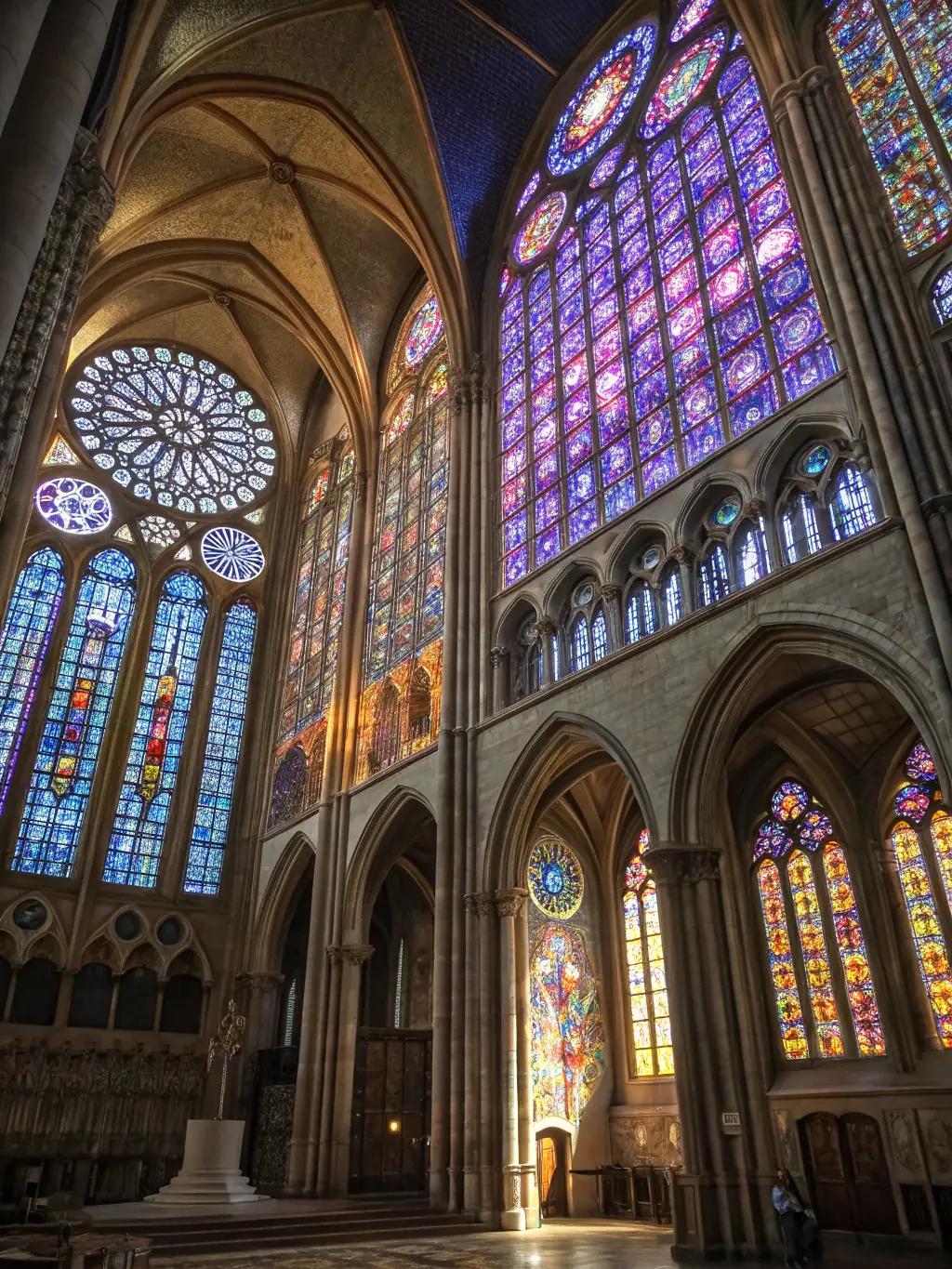 A close-up image of a stained glass window inside the Saint Léonard Chapel, depicting biblical scenes with vibrant colors and intricate details.